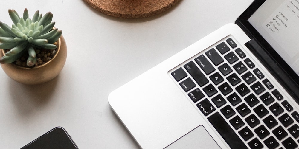 A modern workspace setup with a laptop running WhatsApp Web and a cup of coffee